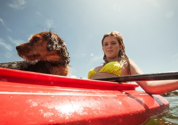Teenage girl and pet dog in kayak